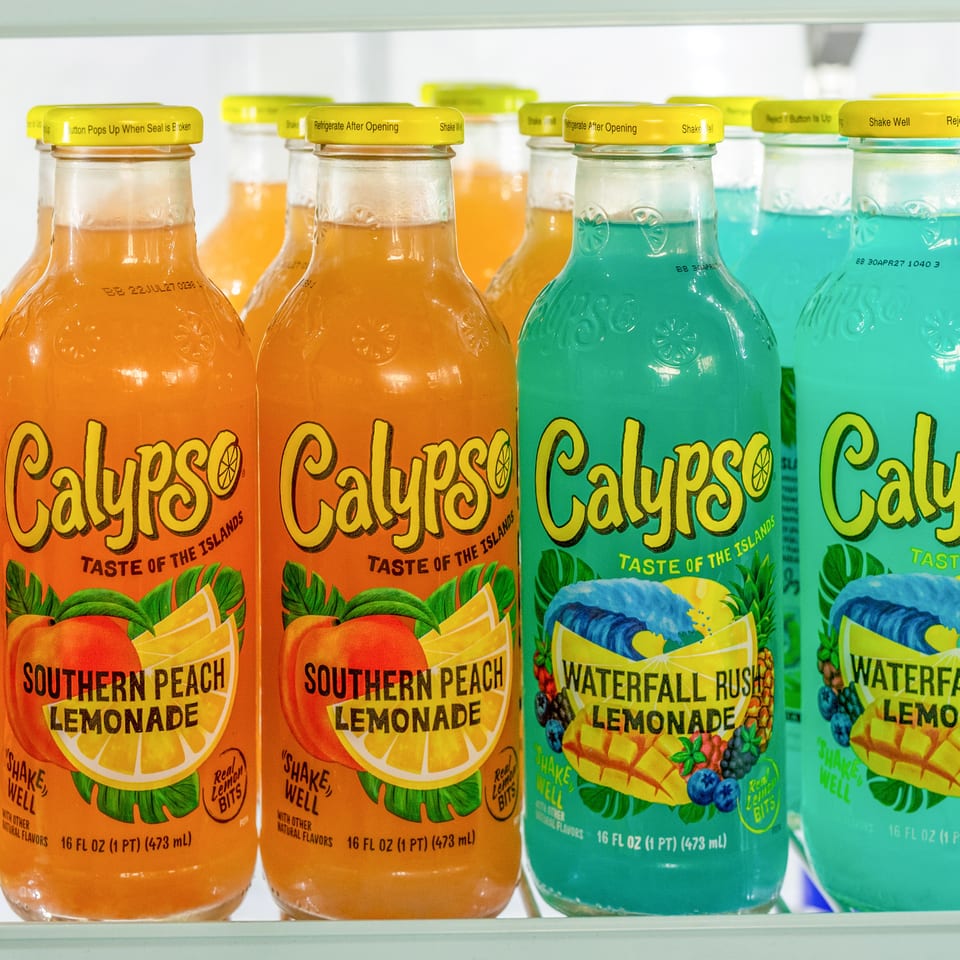 Rows of Calypso bottled beverages, including orange Southern Peach Lemonade and turquoise Waterfall Rush Lemonade.